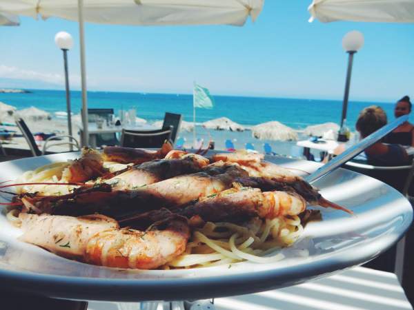 Vue rapprochée des crevettes et des nouilles dans l'assiette contre la mer